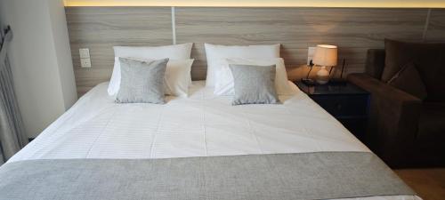 a large bed with white sheets and pillows at Randy's Seaview Studio in Negombo