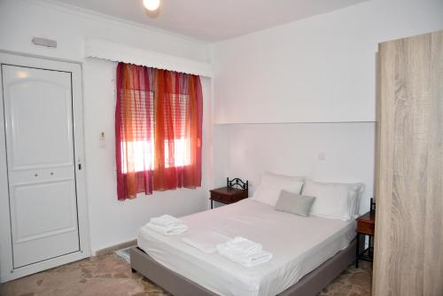 a bedroom with a white bed and a window at Jimmy's Apartments in Pythagoreio