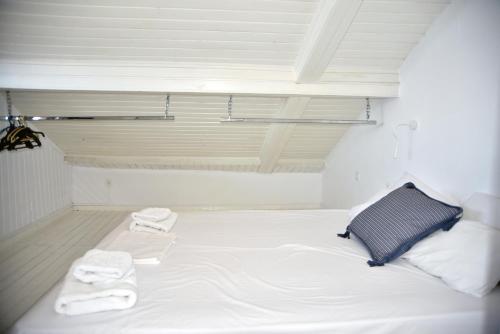 a white bed in a room with towels on it at Jimmy's Apartments in Pythagoreio