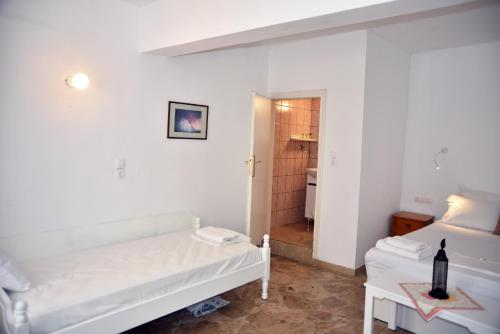 a white room with a bed and a bathroom at Jimmy's Apartments in Pythagoreio