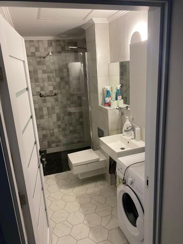 a bathroom with a toilet sink and a washing machine at So Good Studio in Onești
