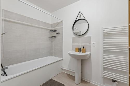 une salle de bain blanche avec un lavabo et un miroir dans l'établissement chic apart with terace and parking, à Rouen