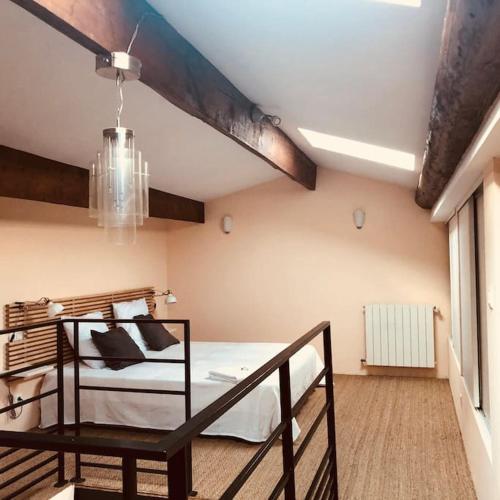 une chambre avec un lit et un lustre dans l'établissement Grand Appartement Mèze idéalement situé, à Mèze