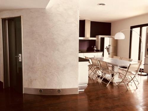 une cuisine et une salle à manger avec une table et des chaises dans l'établissement Grand Appartement Mèze idéalement situé, à Mèze