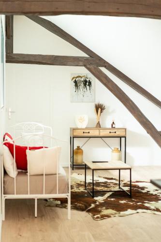 Cette chambre comprend un lit et une table. dans l'établissement Le comble du bonheur, à Cinqueux