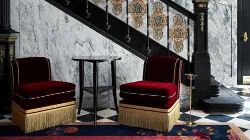 two chairs and a table in a room at Maison Metier, in the Unbound Collection by Hyatt in New Orleans