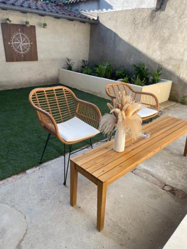 two chairs and a wooden bench with a plant on it at Loft spa, cour arrière privée in Labruguière