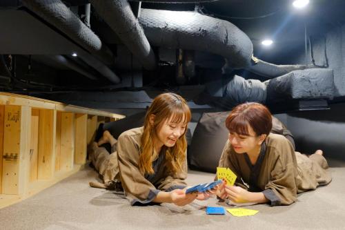 two young girls laying on the floor reading a book at Hotel Naturwald Furano in Furano