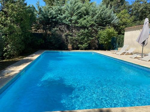 une piscine avec de l'eau bleue dans une cour dans l'établissement Home next to Uzès, à Saint-Siffret