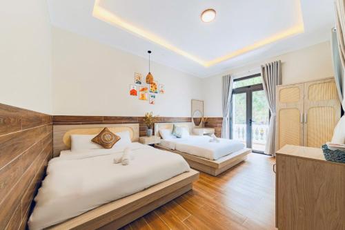 a bedroom with two beds and a large window at White Villa Đà Lạt in Da Lat