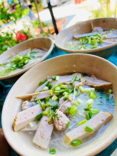 a bowl of soup with meat and vegetables on a table at White Villa Đà Lạt in Da Lat