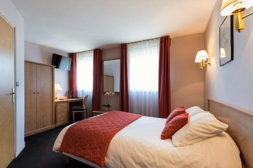 a hotel room with a bed and a desk at Hotel De Clisson Saint Brieuc in Saint-Brieuc