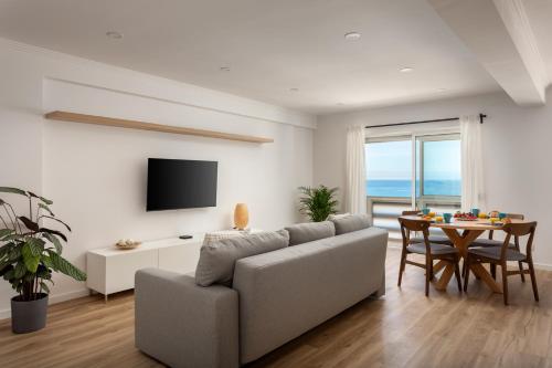 a living room with a couch and a table at Beachfront apartment, 25m from the Beach with AC and Heating in Santa Cruz