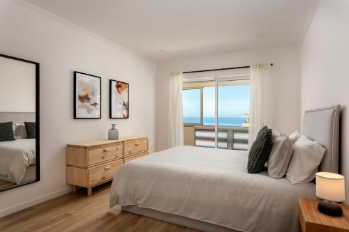 a white bedroom with a large bed and a window at Sunset Beach House in Santa Cruz