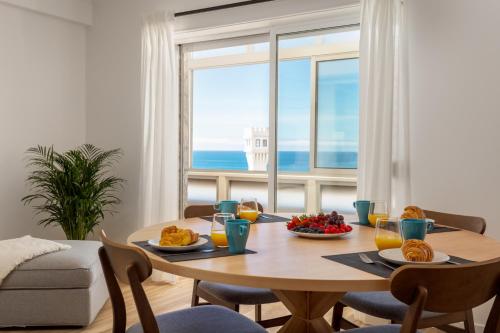 a dining room with a table with food and a window at Beachfront apartment, 25m from the Beach with AC and Heating in Santa Cruz