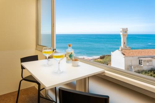 two glasses of wine on a table with a view of the ocean at Beachfront apartment, 25m from the Beach with AC and Heating in Santa Cruz