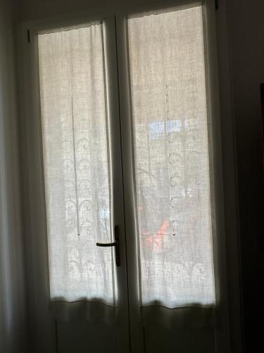 two windows with white curtains in a room at Domus Socolatae Residenza d'Epoca Charming B&B - Adults Only in Follonica