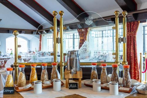 a table with a bunch of gold and silver vases at Hotel Schloss Rheinfels in Sankt Goar