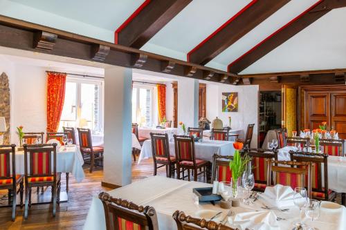 a restaurant with tables and chairs in a room at Hotel Schloss Rheinfels in Sankt Goar