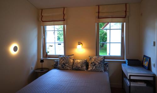 um quarto com uma cama e 2 janelas em Daina Apartments Self check-in em Vilnius