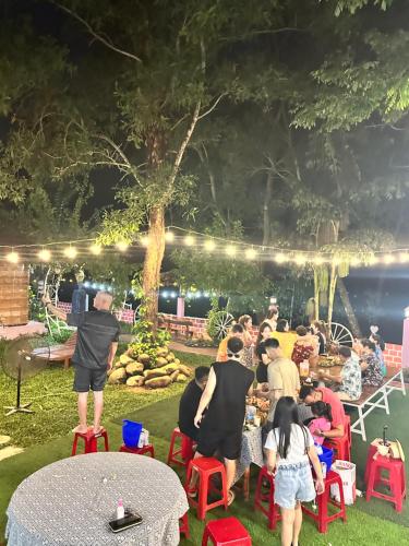 a group of people sitting around a table in the grass at Son River House in Phong Nha