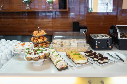 a table topped with different types of cakes and pastries at Hotel Ehrlich Prague in Prague