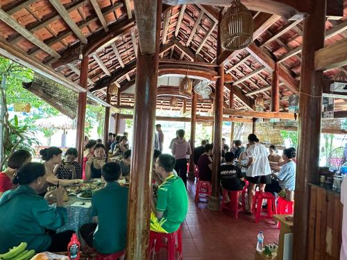 a group of people sitting at tables in a restaurant at Son River House in Phong Nha