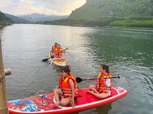 three people are sitting on kayaks in the water at Son River House in Phong Nha
