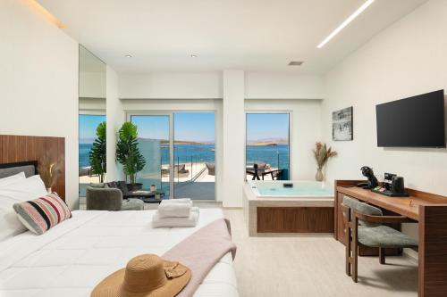 a bedroom with a bed and a desk and a tub at Elia Sea Suites in Chania Town