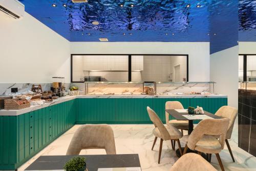 a kitchen with green cabinets and a table and chairs at Elia Sea Suites in Chania Town
