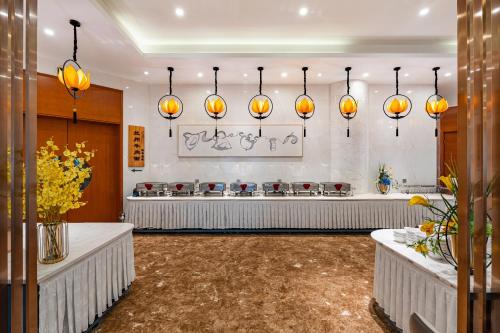 ein Restaurant mit orangefarbenen Lichtern an der Wand in der Unterkunft Beijing Feitian Hotel in Peking