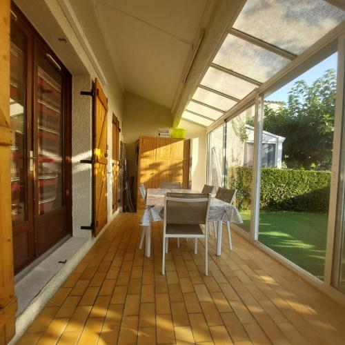 une salle à manger avec une table et des chaises sur un patio dans l'établissement Maison climatisée & wifi avec piscine, à Saint-Cyprien