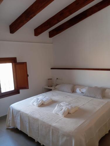 a bedroom with a white bed with towels on it at Apartamentos Turísticos La Bodegueta in Utiel