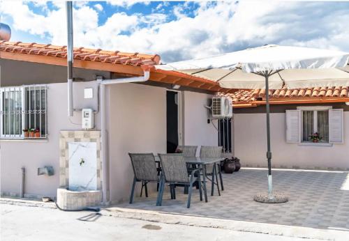 a patio with a table and chairs and an umbrella at Angela Apartment in Dhalamanára