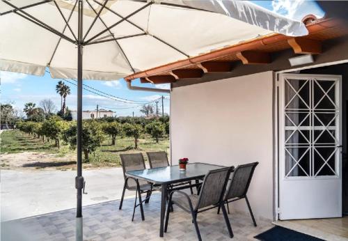 a table with chairs and an umbrella on a patio at Angela Apartment in Dhalamanára