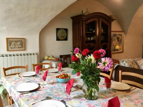 une table de salle à manger avec un vase de fleurs dessus dans l'établissement Les Asphodeles chambre familiale Lilah, à Saint-Hippolyte-du-Fort
