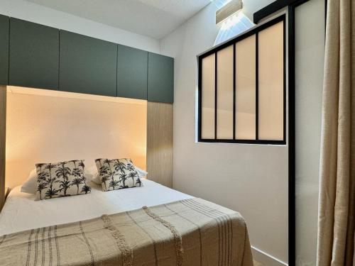 - une chambre avec un lit avec deux oreillers et une fenêtre dans l'établissement Jolie 2 pièces plage - No 59 Fief du Roy, à Port-la-Nouvelle