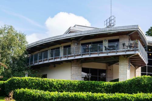 a building with a balcony and bushes at DoubleTree by Hilton Bristol South - Cadbury House in Yatton