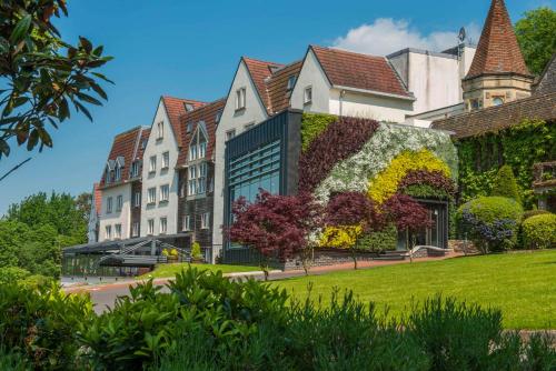 an exterior view of a building with plants on it at DoubleTree by Hilton Bristol South - Cadbury House in Yatton