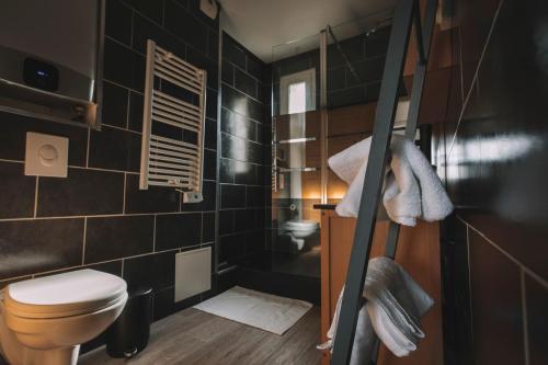 La salle de bains est pourvue de toilettes et de carrelage noir. dans l'établissement Le Perlina, à Annecy