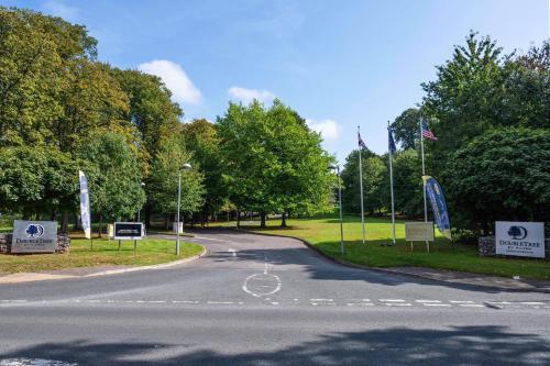 a winding road with flags on the side of the road at DoubleTree by Hilton Bristol South - Cadbury House in Yatton