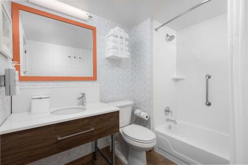 a bathroom with a sink and a toilet and a mirror at Hampton Inn Louisville Airport Fair/Expo Center in Louisville