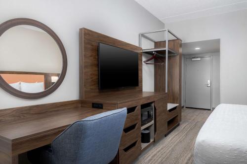 a hotel room with a tv and a mirror at Hampton Inn Louisville Airport Fair/Expo Center in Louisville