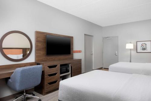 a hotel room with a bed and a mirror at Hampton Inn Louisville Airport Fair/Expo Center in Louisville