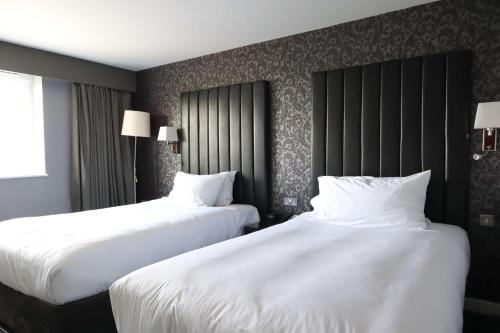 two beds in a hotel room with white sheets at DoubleTree by Hilton Bristol South - Cadbury House in Yatton
