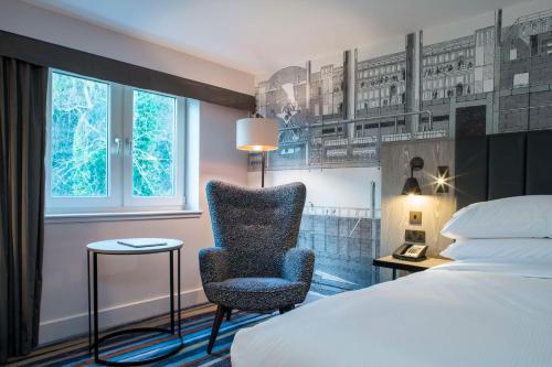 a hotel room with a chair and a bed at DoubleTree by Hilton Bristol South - Cadbury House in Yatton
