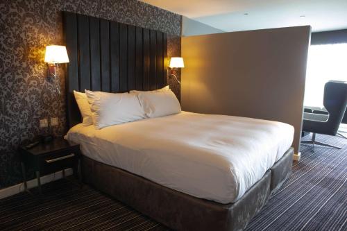 a hotel room with a bed with a large headboard at DoubleTree by Hilton Bristol South - Cadbury House in Yatton