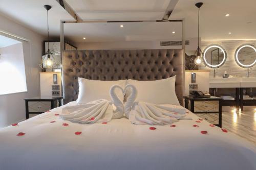 a bedroom with a white bed with two wings at DoubleTree by Hilton Bristol South - Cadbury House in Yatton