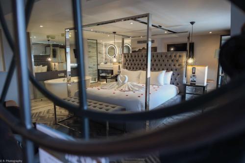 a bedroom with a large white bed and a mirror at DoubleTree by Hilton Bristol South - Cadbury House in Yatton