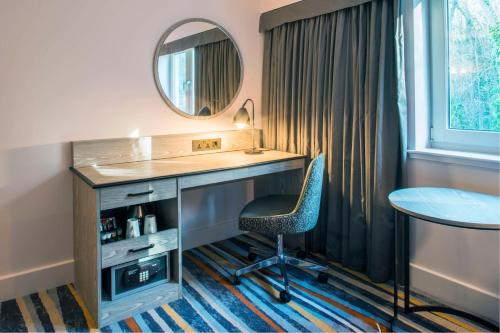 a room with a desk and a chair and a mirror at DoubleTree by Hilton Bristol South - Cadbury House in Yatton